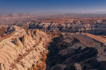 Fototapeta na wymiar Panoramic view of Goreme national park with over deep canyons, valleys sunset Cappadocia. Popular Turkey touristic destination, aerial top view drone