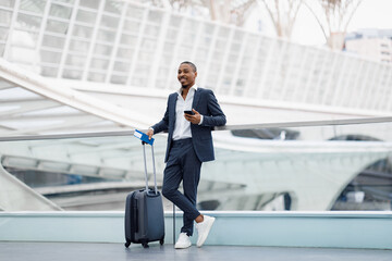 Handsome African American Businessman Standing With Suitcase In Airport