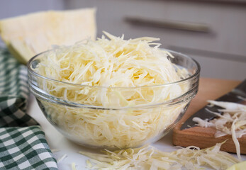 Chopped cabbage in a glass bowl on the table. Healthy food concept. Close-up. Selective focus.