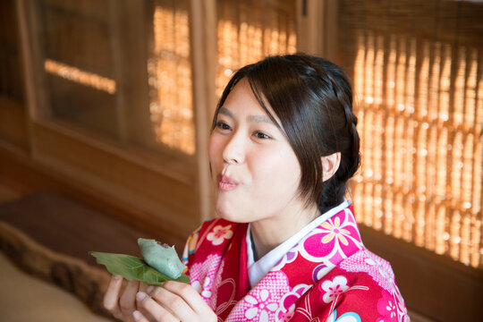 柏餅を食べている着物姿の女性