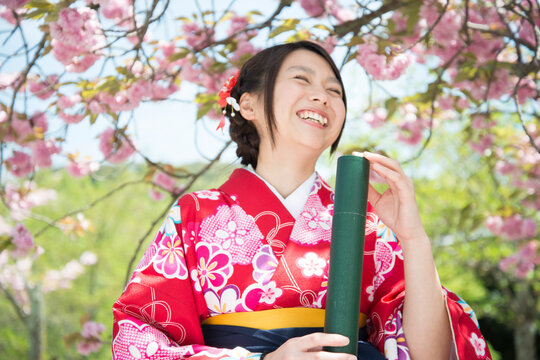 卒業証書の筒を持っている袴姿の女性