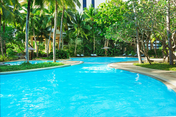 Beautiful luxury swimming pool with palm trees. Thai, Phuket. Vacation concept.