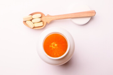 Vitamins pills in a spoon on a white background