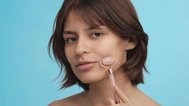 The beautiful young lady uses the quart role on her face. Facial treatment