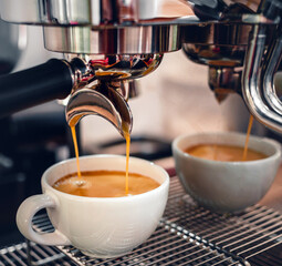 Espresso coffee extraction from a professional coffee machine with a bottomless filter, Close-up of a coffee drop  from the coffee machine.
