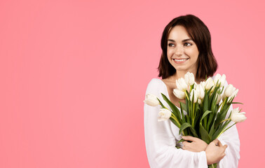 Gift at spring holiday, ad and offer. Happy young european lady with bouquet of white tulips, enjoy lifestyle