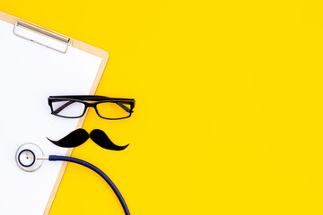 Fototapeta premium Glasses with a mustache and doctor clipboard. Male medical checkup concept