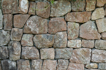 The texture of the stone fence under the rock