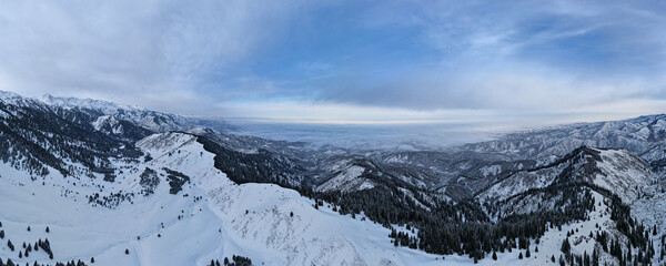 Obraz premium Panoramic view of the winter snowy peaks of the mountains. Panorama of the mountains
