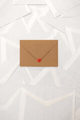 Brown craft paper envelope with a red heart sticker on a pole if white empty blanc envelope background with copy space. love romantic mock up. Saint Valentine frame wallpaper.