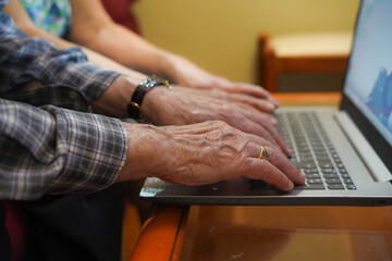 unrecognizable older couple typing on the computer. technology in old age