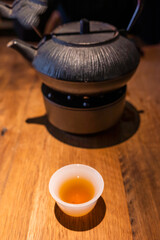 Cup of Chinese tea and teapot on a wooden table close-up view - 571555496