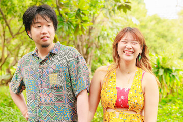 手をつないで自然の中を散歩する日本人カップル