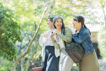 カメラを持って笑顔の3人の女性