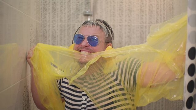 a man dances in the shower and tears off his clothes. slow motion video. tears clothes with his teeth. High quality Full HD video recording