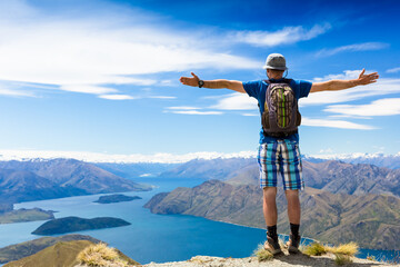 hiker at the top his hands raised enjoy sunny day. New Zealand