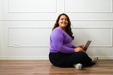 Cheerful big woman doing online shopping