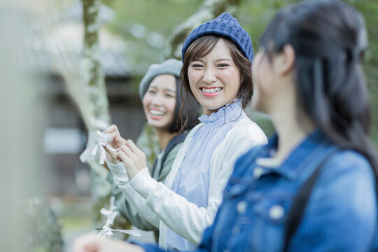 おみくじを結ぶ若い女性