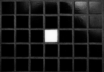 One white tile among black. Stand out, be different, do not be like everyone else. Do not lose yourself, you're special. Background black tile