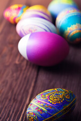 Fototapeta premium Handmade painted colorful easter eggs decoration on wood table top view with empty space made with generative ai