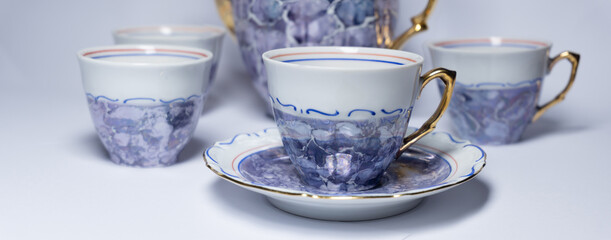 Old porcelain cups and kettle for tea or coffee isolated on white background. Banner for website with coffee, tea, food, drinks.