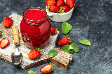 Strawberry jam in the glass jar, Homemade strawberry marmelade and fruits on a dark background. top view. place for text