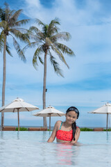 Happy girl enjoying summer vacations in a pool. Summer holidays, children's swimming, Pool woman on holidays in tropical resort swimming. summer vacation concept.
