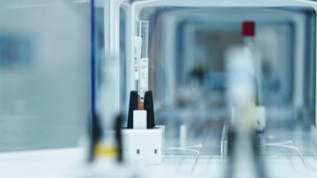 Close-up of empty test tubes moving around inside an automated lab glazed line. Lab concept. High quality 4k footage