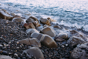  Seashore with pebbles and stones in the evening at sunset