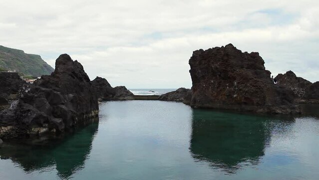 natural pool between the stones on the coast of the Atlantic on the island of Madeira on a cloudy day in summer