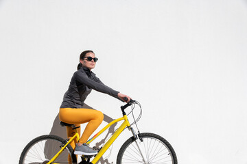 Fit, female cyclist riding a yellow bicycle