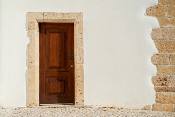 Fototapeta na wymiar Wooden door in a white wall