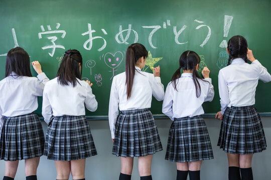 黒板にチョークで書く女子中学生