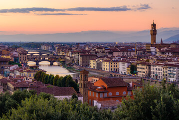 Fototapeta na wymiar The Florence cityscape with the illuminated Ponte Vecchio over Arno river and illuminated Palazzo Vecchio in an colourful twilight.