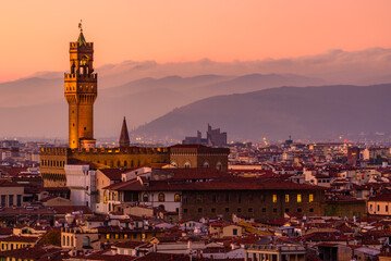 The illuminated Palazzo Vecchio in Florence in an orange sunset.