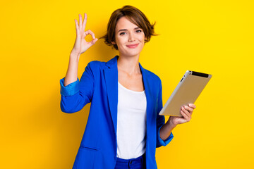 Photo of charming positive lady dressed blue blazer showing okey chatting modern device isolated yellow color background