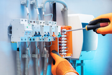 Electrician worker at work on an electrical panel. Electrician, repair electrical equipment concept.