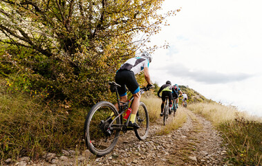 group male athlete cyclist riding mountain trail