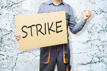 Protesting worker. man holding poster with protest messag.