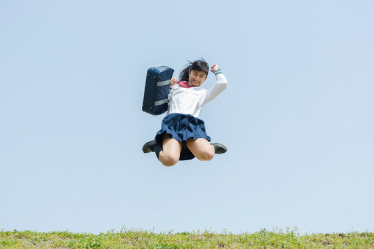 青空バックにジャンプする女子校生
