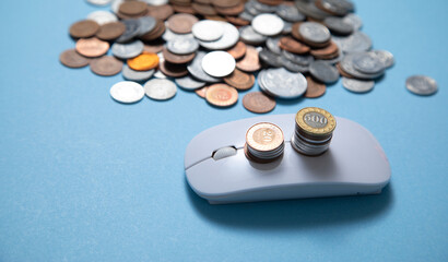 Computer mouse and coins on the blue background.