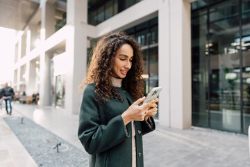Young woman reading a message or using the phone in the city