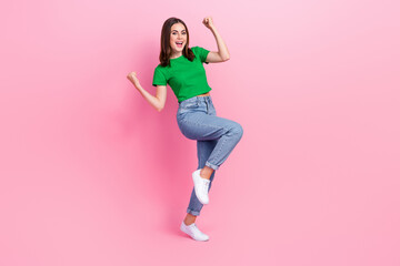 Fototapeta na wymiar Full length photo of sweet lucky lady dressed green t-shirt screaming rising fists empty space isolated pink color background