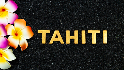 Tahiti - Flowers and text in black sand