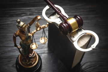  Statue of Lady Justice, handcuffs, book and gavel.
