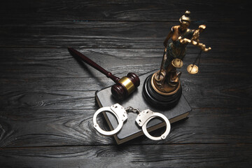  Statue of Lady Justice, handcuffs, book and gavel.