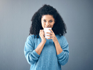 Coffee, tea and portrait of black woman drinking an espresso in a cup isolated in a studio gray...