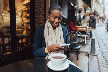 Young african woman using smart phone in a modern cafe