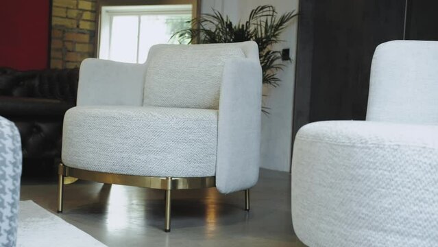Dolly shot of gray fabric minimalist chair in loft stile office. Fashionable gray chair with metal legs. Slow motion shot of interior detail design of modern gray chair at office. 