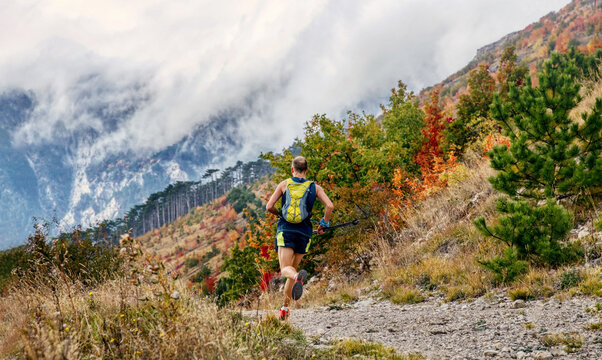athlete runner with trekking poles run autumn mountain race